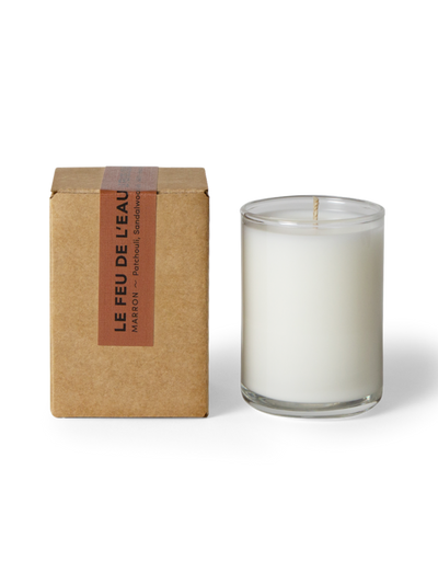 Glass candle with a cardboard box labeled 'Le Feu de L'Eau' on a white background