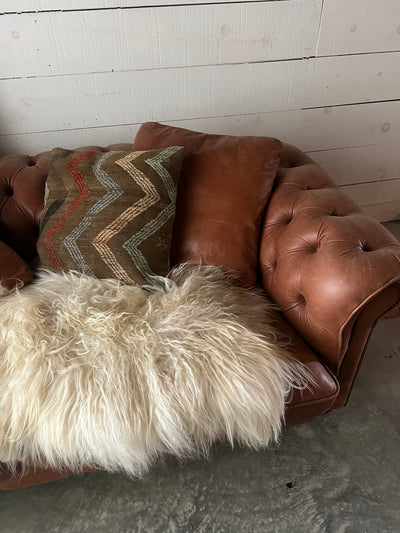 Vintage Turkish Pillow Cover on a vintage Chesterfield leather sofa  with an sheepskin