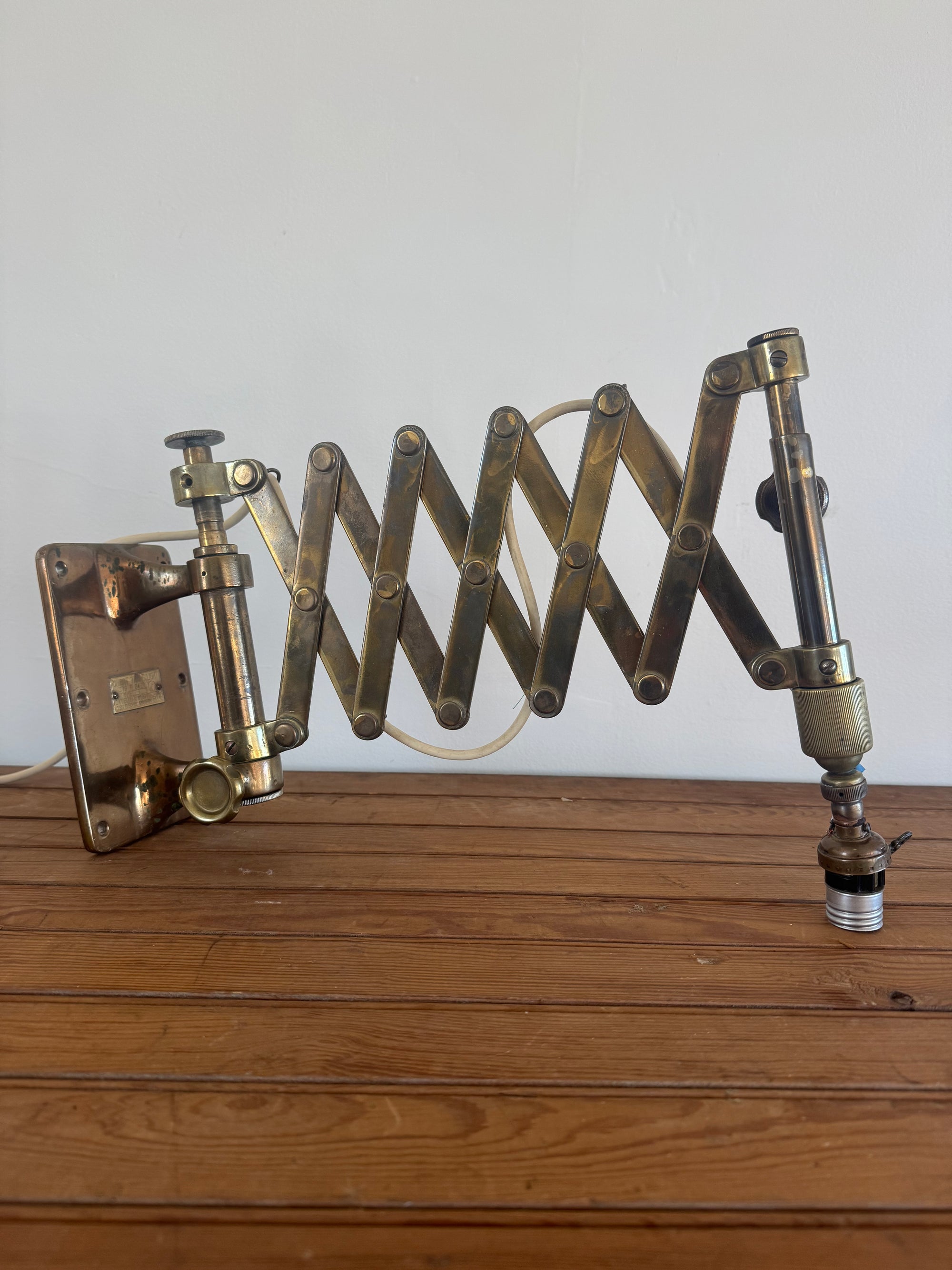 Brass spring-loaded door stopper attached to a wooden door.