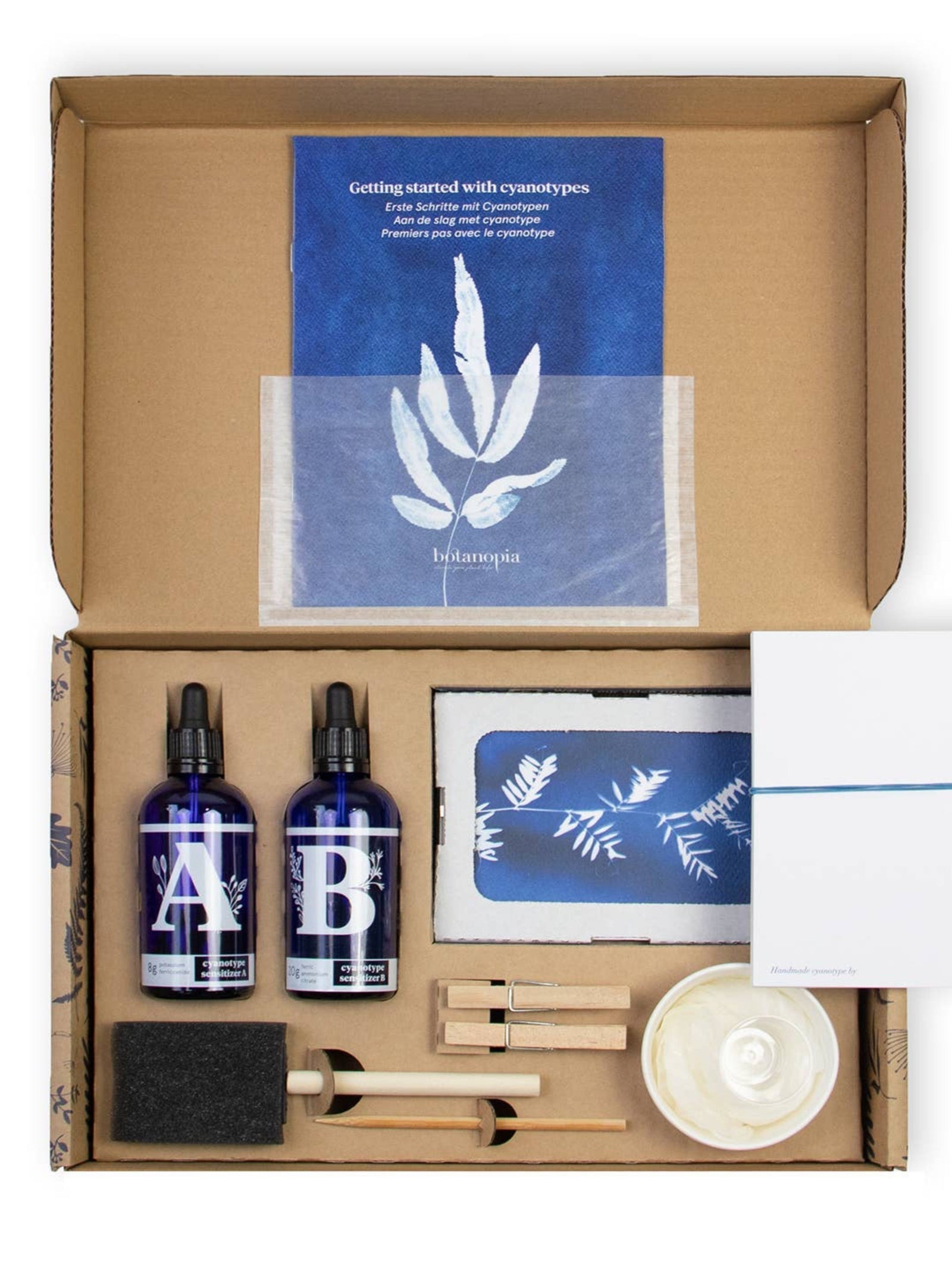 Open cardboard box containing beauty products and a blue leaf-themed card.